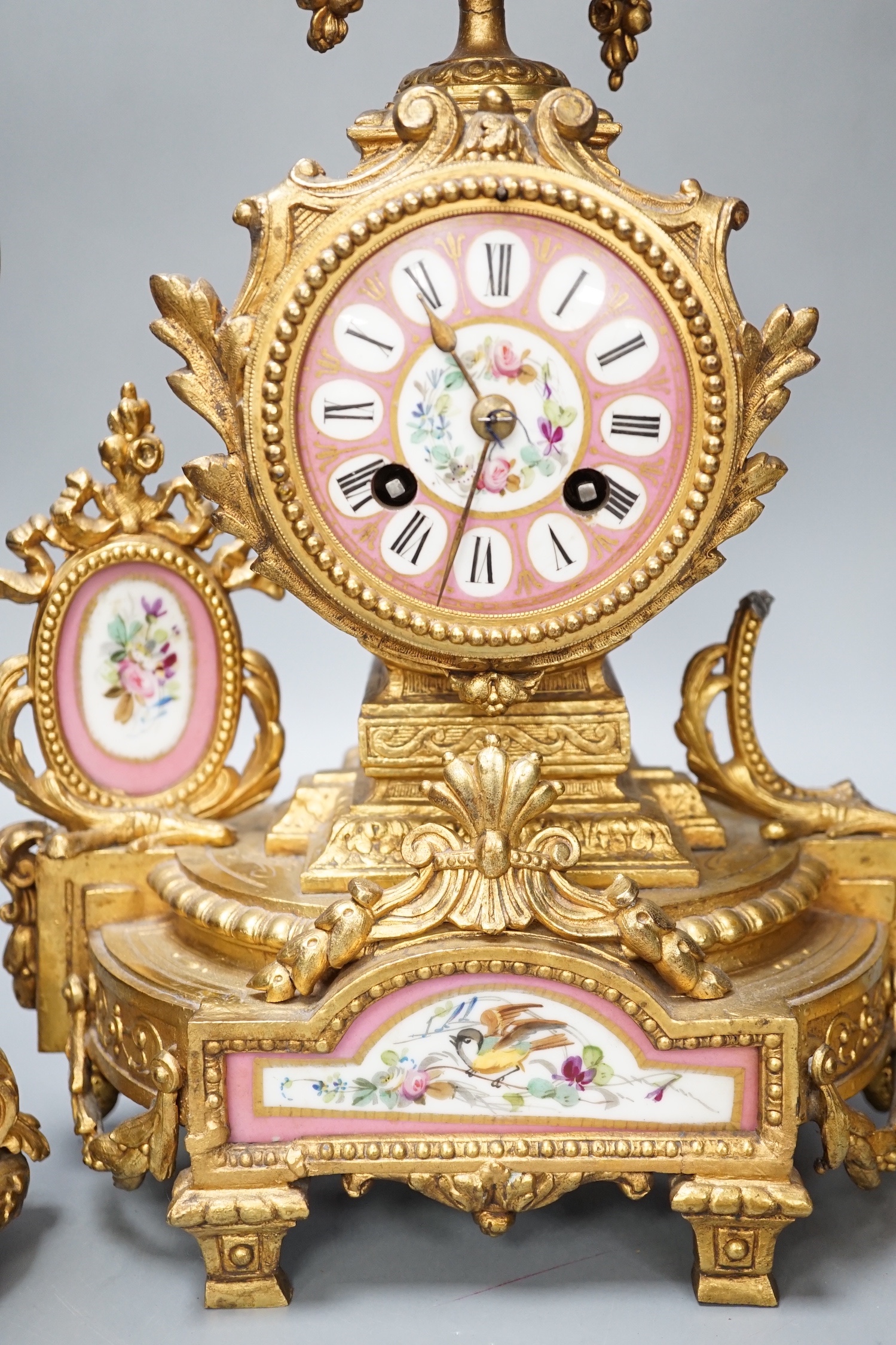 A French gilt metal and porcelain clock garniture. 36.5cm